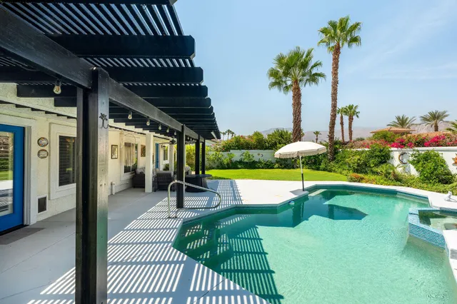 a view of a chairs and table in patio with swimming pool