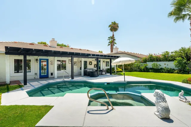 a view of a house with swimming pool and a yard