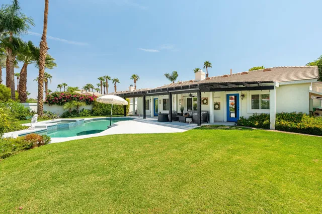 a front view of a house with swimming pool having outdoor seating