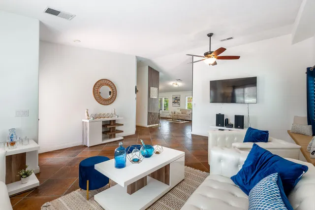 a living room with furniture a rug and a flat screen tv