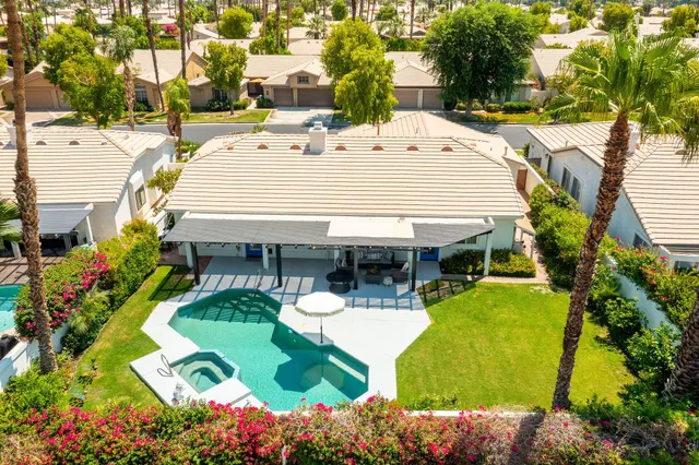 a view of a patio with table and chairs potted plants and large tree