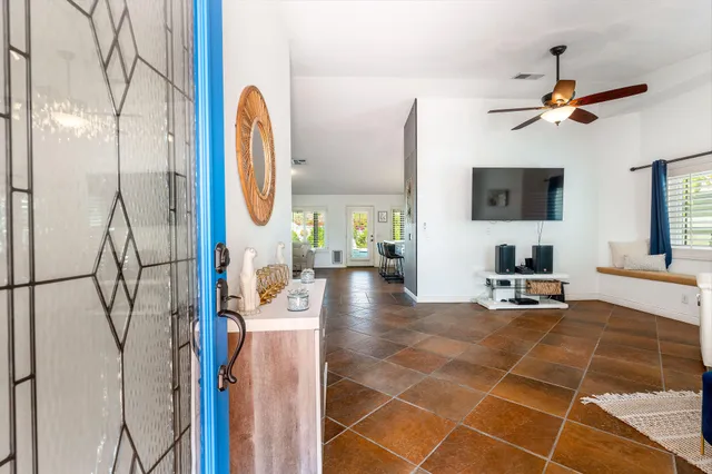 a living room with patio furniture and a flat screen tv