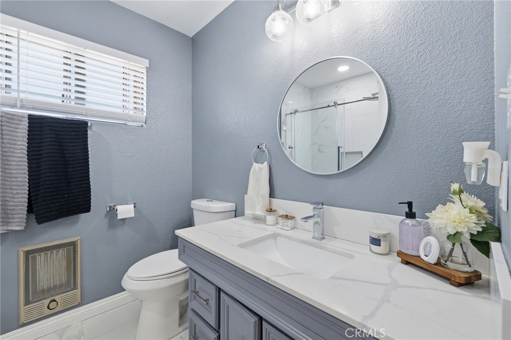 1032 South Farragut Street Ridgecrest, CA 93555 - Photo 13 of 22 a bathroom with a sink a toilet and a mirror