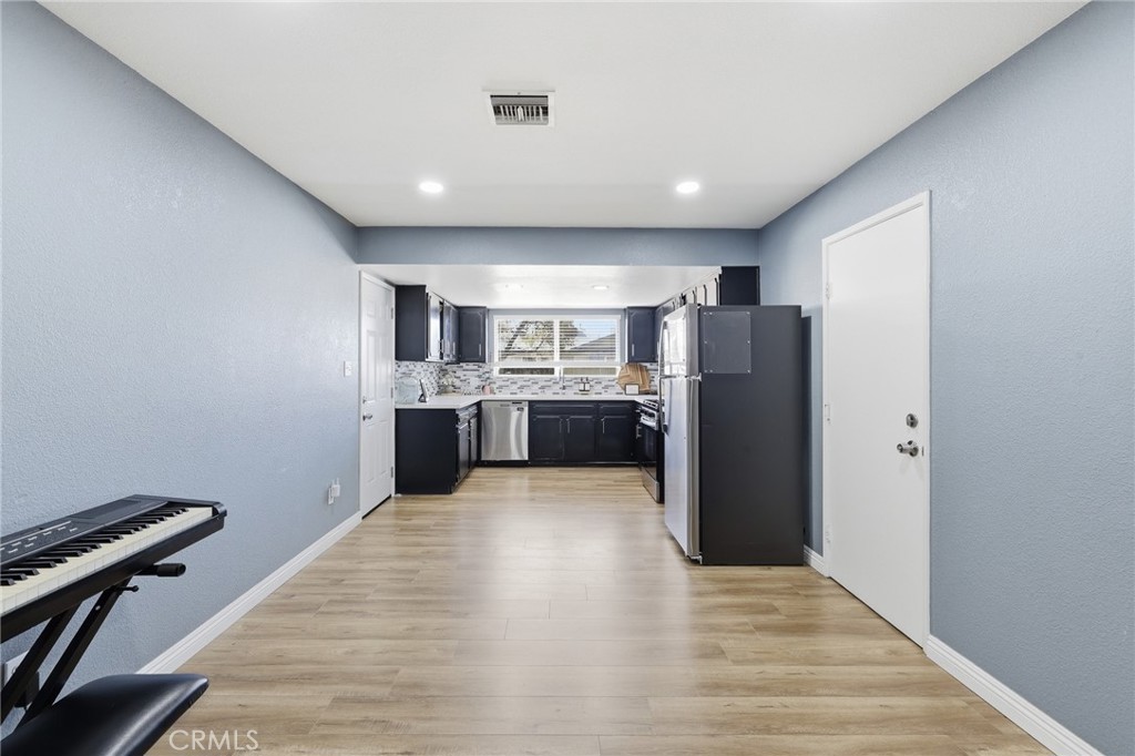 1032 South Farragut Street Ridgecrest, CA 93555 - Photo 10 of 22 a view of kitchen with refrigerator microwave and wooden floor