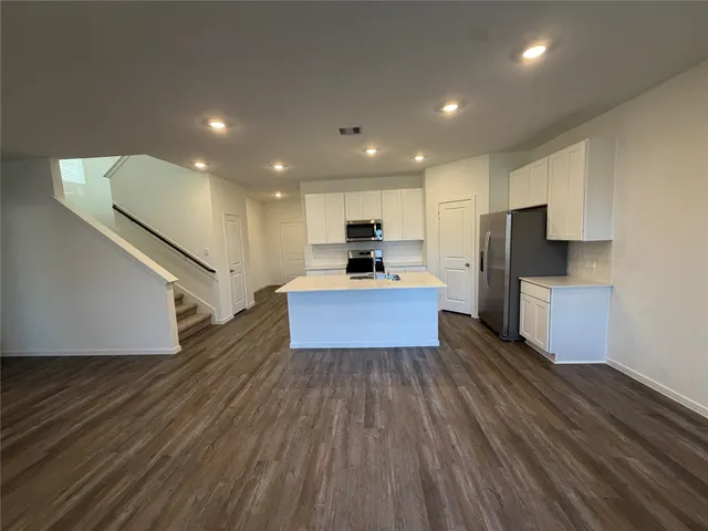 a kitchen with a refrigerator and a stove top oven