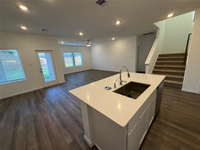 a kitchen with a sink and wooden floor