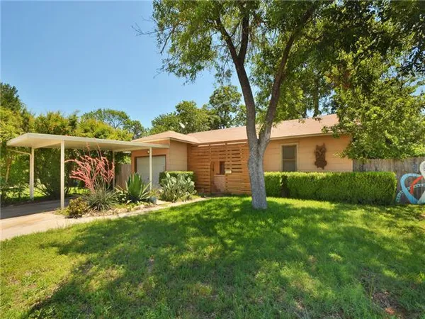 a view of a house with a yard and a tree