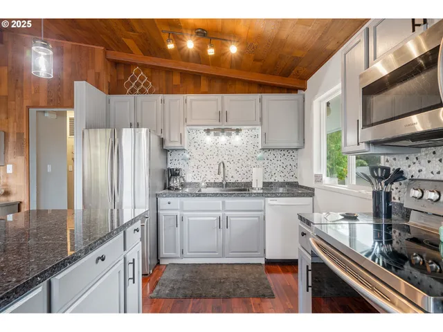a kitchen with stainless steel appliances granite countertop a sink stove and refrigerator