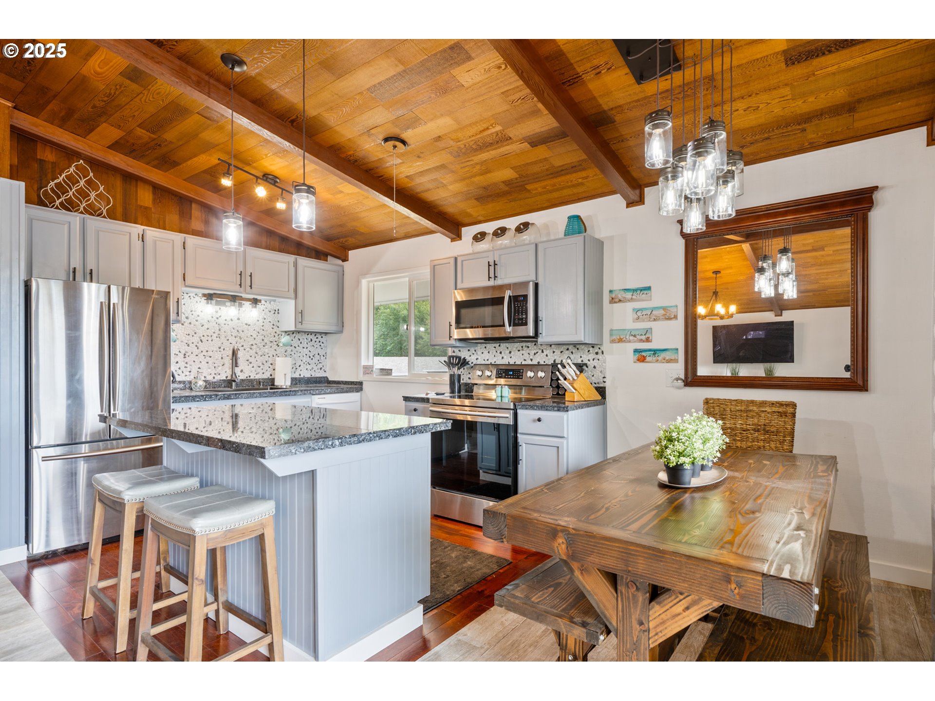 1960 Alder Cove Road West Netarts, OR 97141 - Photo 15 of 41 a kitchen with stainless steel appliances kitchen island granite countertop a sink dishwasher a stove a refrigerator with a dining table and chairs