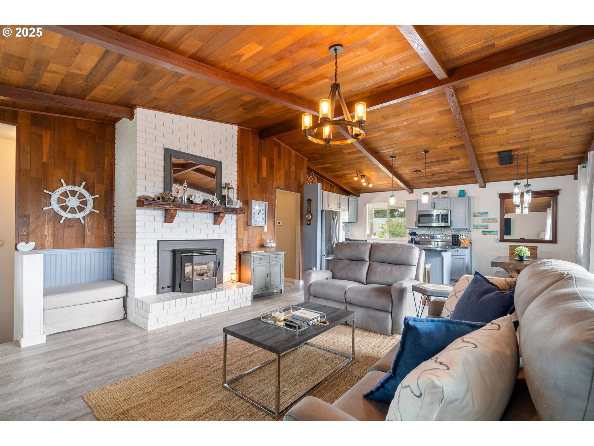 1960 Alder Cove Road West Netarts, OR 97141 - Photo 6 of 41 a living room with furniture a chandelier and a fireplace
