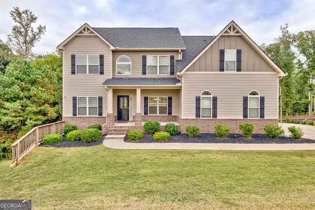 a front view of a house with a yard and potted plants