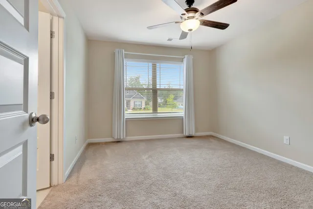 en empty room with closet and a ceiling fan