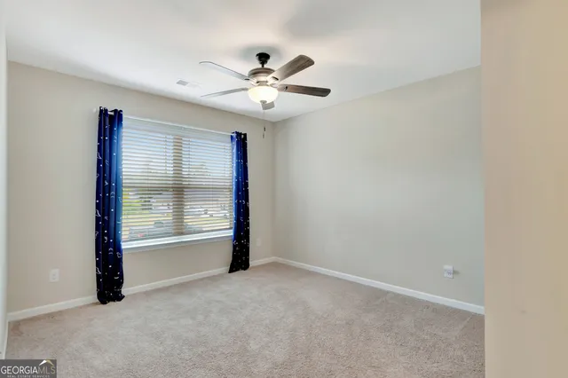 a bed sitting in a bedroom next to a window