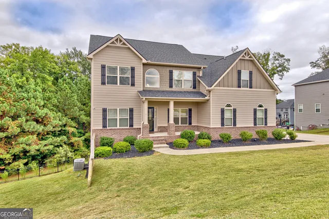 a front view of a house with a garden and plants