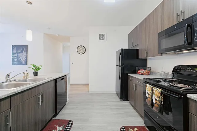 a kitchen with a refrigerator a stove top oven a sink and cabinets
