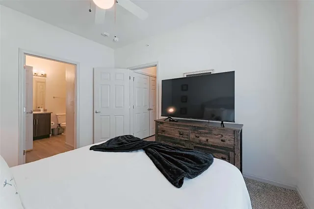 a bedroom with a bed and a flat tv screen on dresser