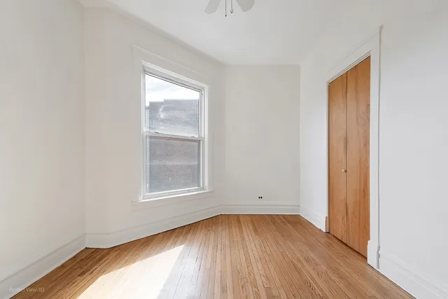 an empty room with a hardwood and a window