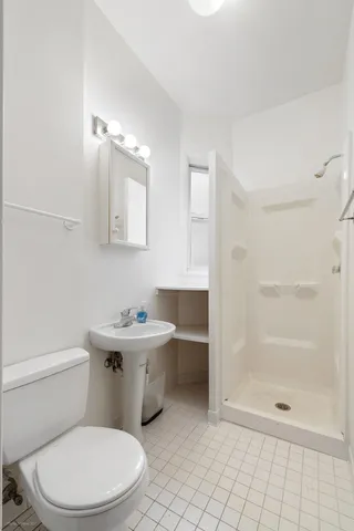a bathroom with a sink a toilet and shower