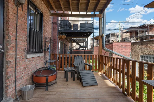 a porch area with wooden floor table and chairs