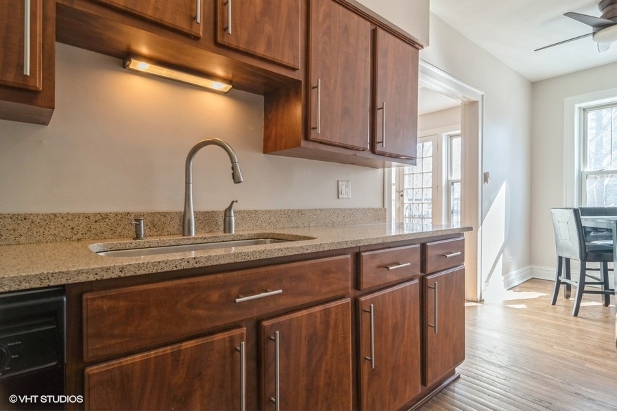 6251 North Sheridan Road, Unit 8 Chicago, IL 60660 - Photo 5 of 11 a kitchen with stainless steel appliances granite countertop a sink a stove cabinets and wooden floor