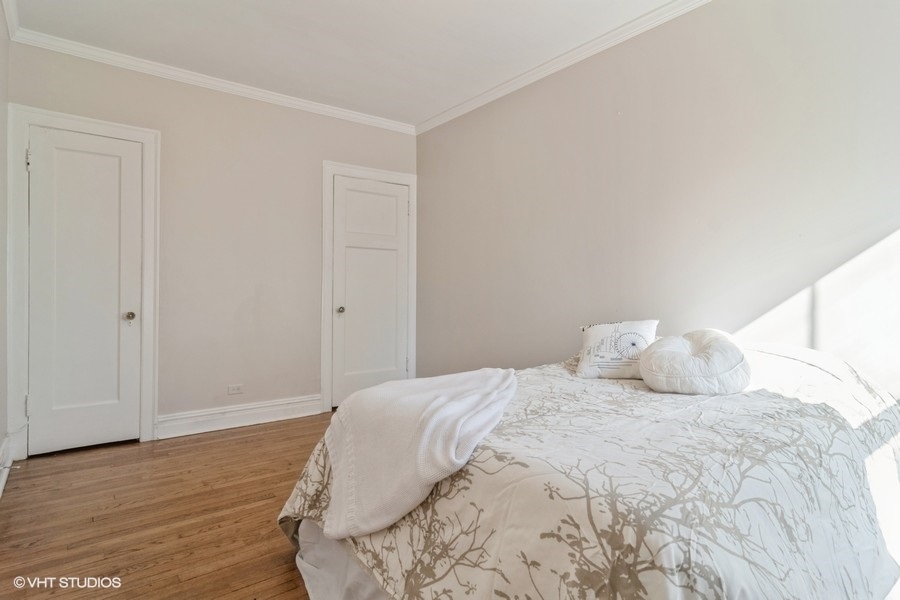 6251 North Sheridan Road, Unit 8 Chicago, IL 60660 - Photo 7 of 11 a bedroom with a bed and wooden floor