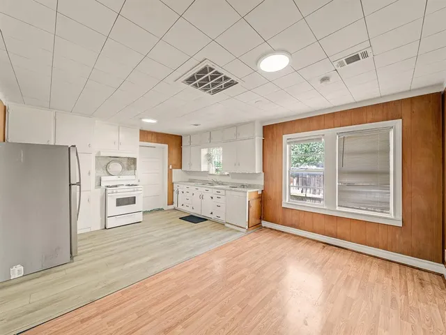 a view of a kitchen with a fridge wooden floor and a window