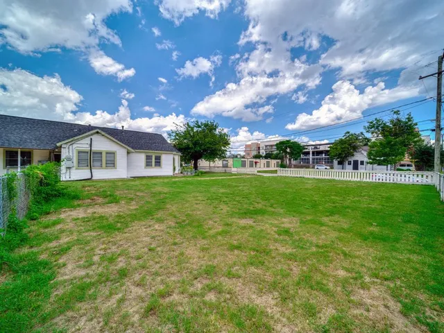 a view of a yard with wooden fence