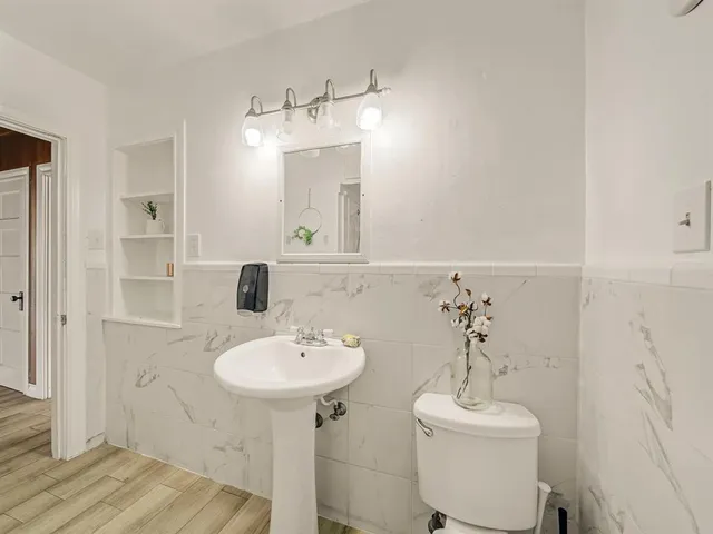 a bathroom with a toilet sink and mirror