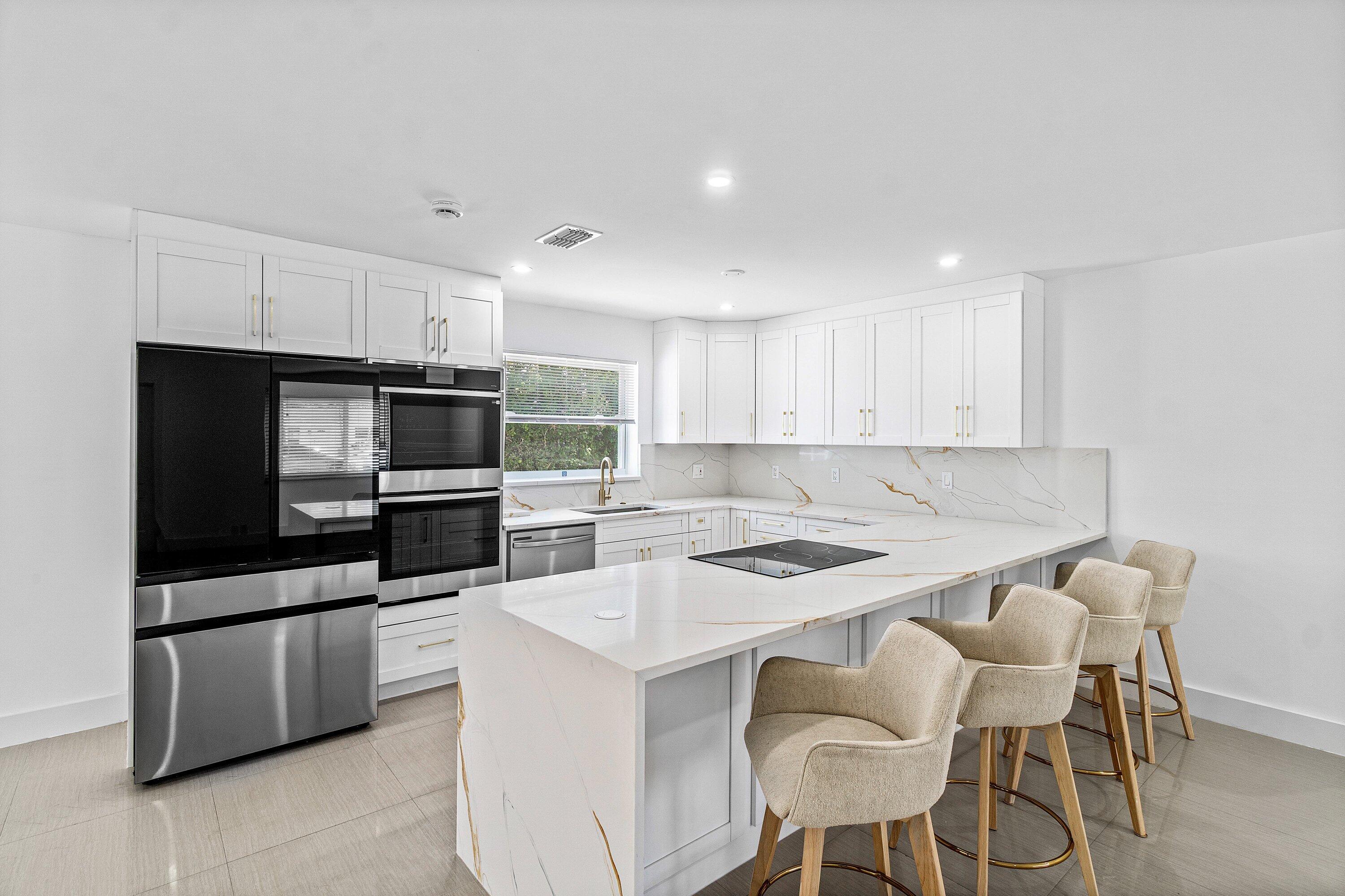 1531 Northwest 4th Street Boca Raton, FL 33486 - Photo 6 of 34 a kitchen with stainless steel appliances a table and chairs