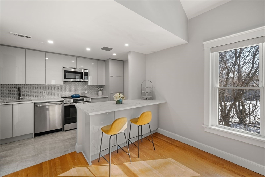 53 North Mead Street, Unit C10 Boston, MA 02129 - Photo 3 of 15 a kitchen with a sink a stove a microwave a counter top space and cabinets