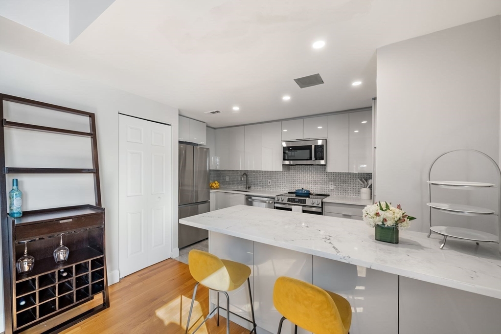 53 North Mead Street, Unit C10 Boston, MA 02129 - Photo 4 of 15 a kitchen with stainless steel appliances granite countertop a sink a stove and a refrigerator