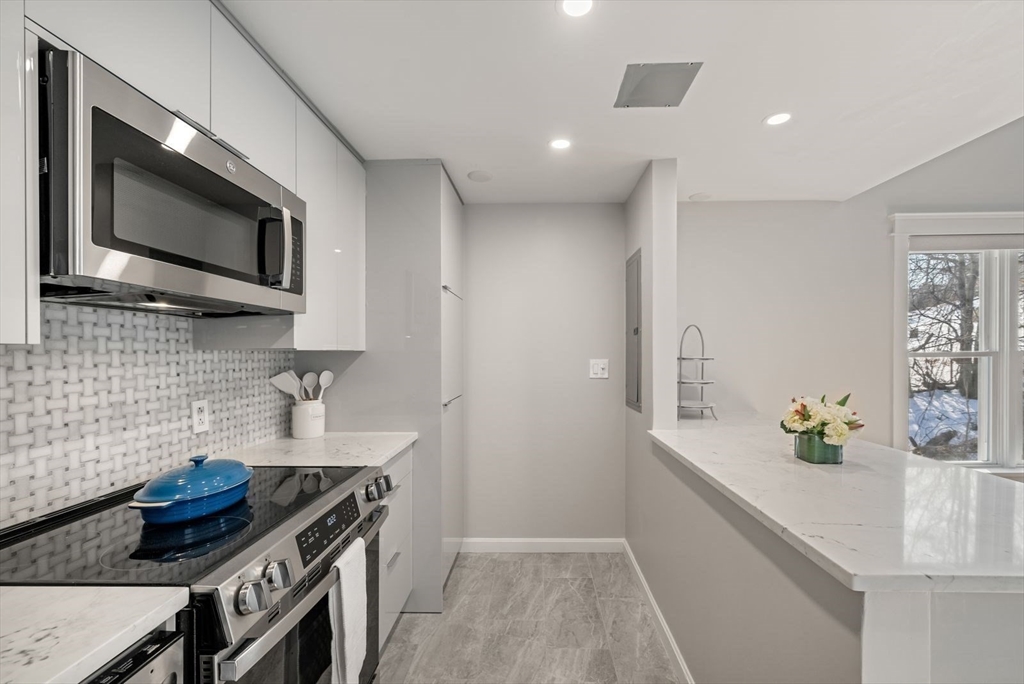 53 North Mead Street, Unit C10 Boston, MA 02129 - Photo 5 of 15 a kitchen with stainless steel appliances granite countertop a sink and a stove