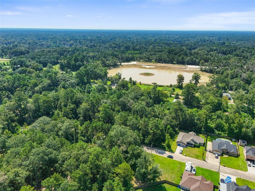 an aerial view of residential houses with outdoor space and trees