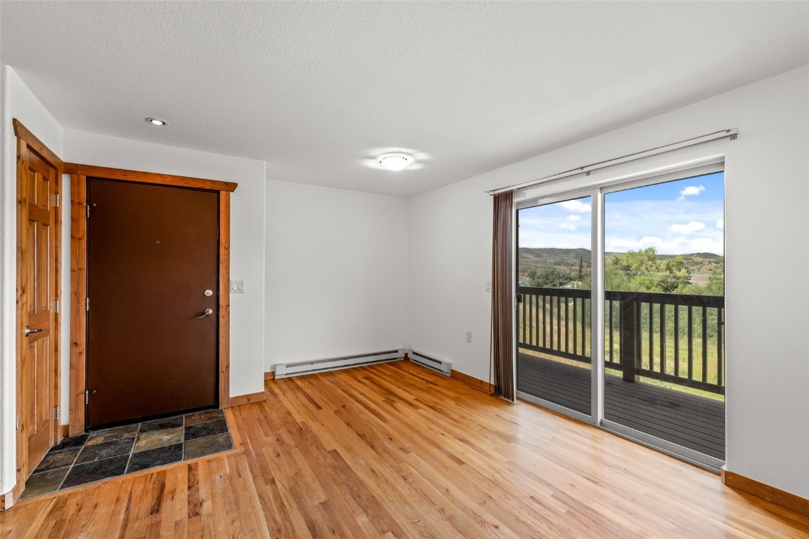 127 Oak Ridge Circle, Unit 104 Oak Creek, CO 80467 - Photo 11 of 26 wooden floor in an empty room with a window