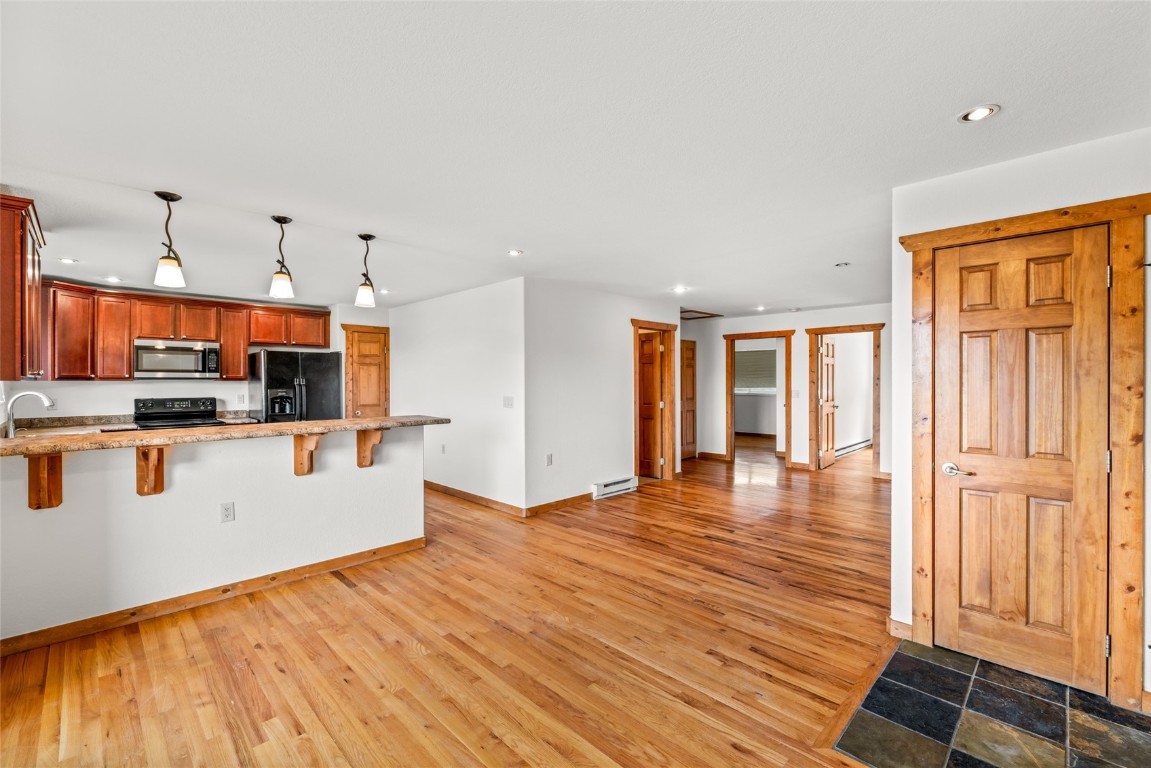 127 Oak Ridge Circle, Unit 104 Oak Creek, CO 80467 - Photo 12 of 26 a view of a kitchen with kitchen island stainless steel appliances wooden floor and window