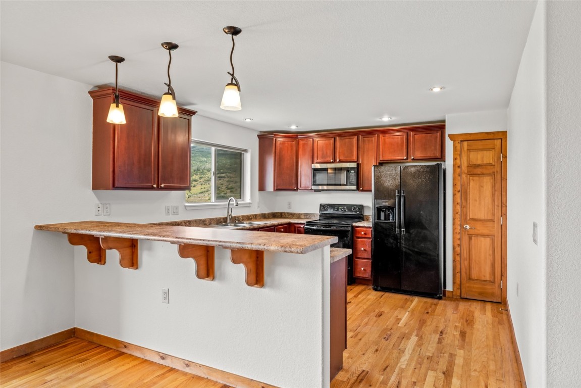 127 Oak Ridge Circle, Unit 104 Oak Creek, CO 80467 - Photo 13 of 26 a kitchen with stainless steel appliances granite countertop a refrigerator a sink dishwasher a stove and a flat screen tv