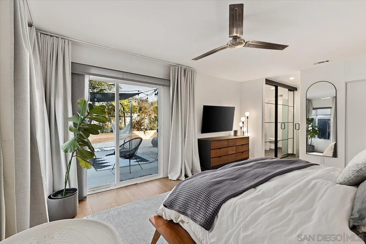 101 Rodney Avenue Encinitas, CA 92024 - Photo 13 of 31 a bedroom with a large bed a flat screen tv and a couch