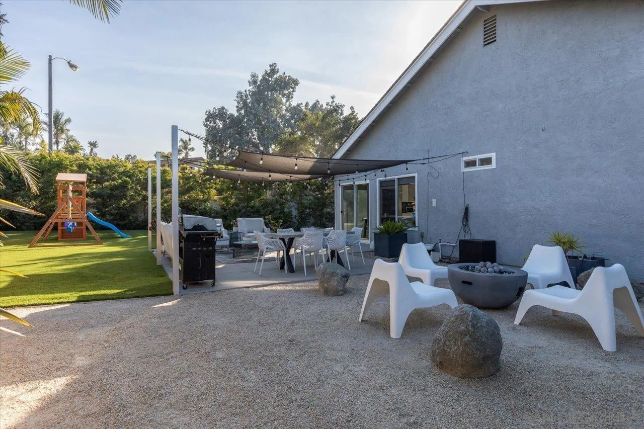 101 Rodney Avenue Encinitas, CA 92024 - Photo 28 of 31 a view of a patio with table and chairs potted plants and a palm tree