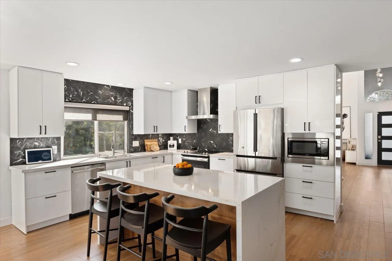 101 Rodney Avenue Encinitas, CA 92024 - Photo 8 of 31 a kitchen with stainless steel appliances a stove a refrigerator a sink a stove and white cabinets with wooden floor