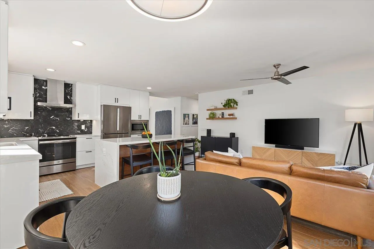 101 Rodney Avenue Encinitas, CA 92024 - Photo 9 of 31 a kitchen with stainless steel appliances granite countertop a stove top oven a sink a dining table and chairs with wooden floor