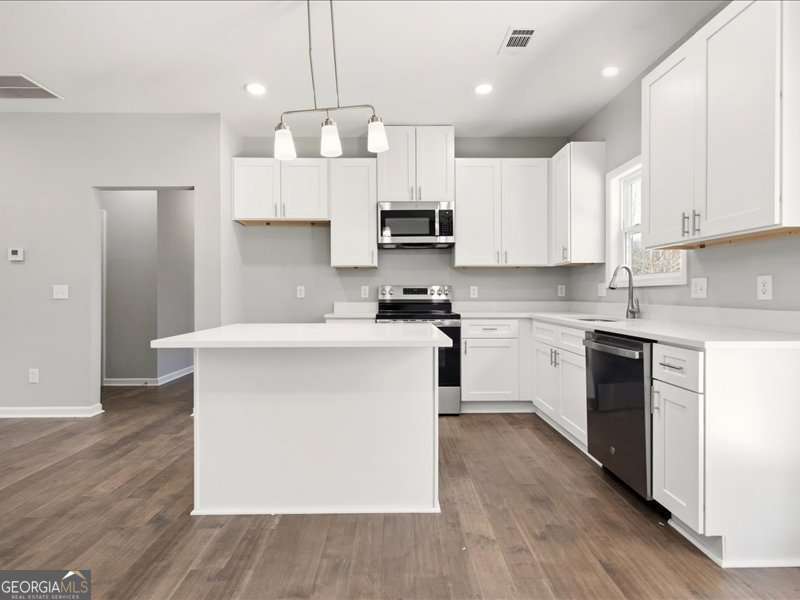 1495 Kansas Jake Road Waco, GA 30182 - Photo 12 of 34 a kitchen with kitchen island granite countertop a white stove top oven cabinets and a refrigerator