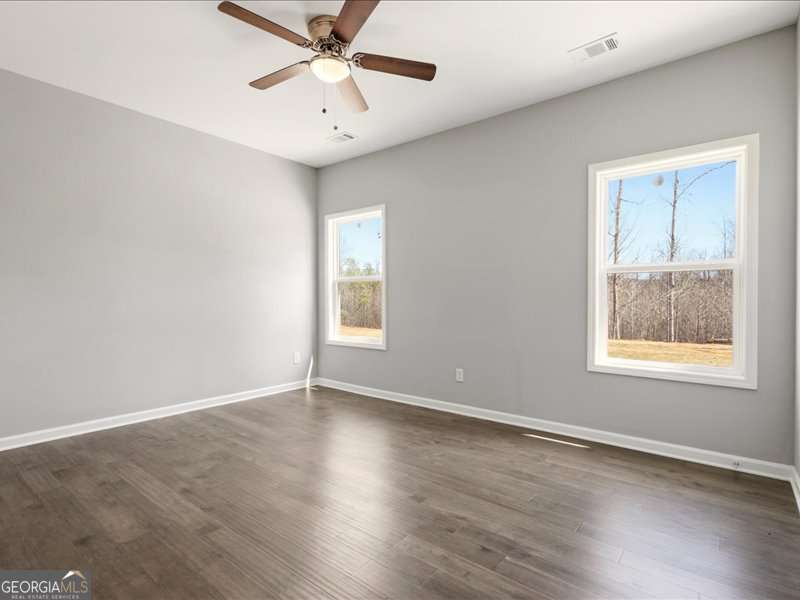 1495 Kansas Jake Road Waco, GA 30182 - Photo 13 of 34 an empty room with wooden floor fan and windows