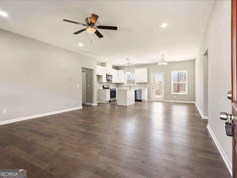 1495 Kansas Jake Road Waco, GA 30182 - Photo 8 of 34 a view of an empty room with wooden floor and a ceiling fan