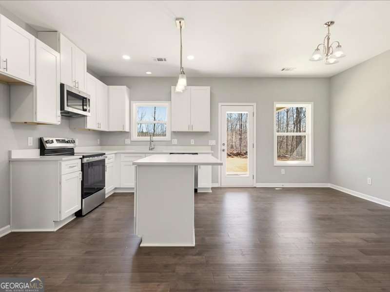 1495 Kansas Jake Road Waco, GA 30182 - Photo 9 of 34 a kitchen with stainless steel appliances granite countertop a stove a sink dishwasher a refrigerator white cabinets and wooden floor next to a window