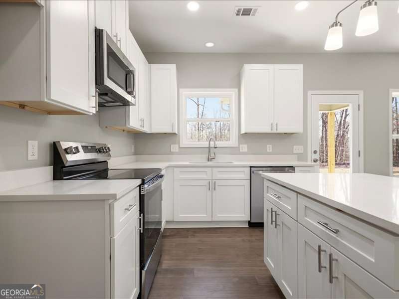 1495 Kansas Jake Road Waco, GA 30182 - Photo 10 of 34 a kitchen with cabinets appliances a sink and a counter top space