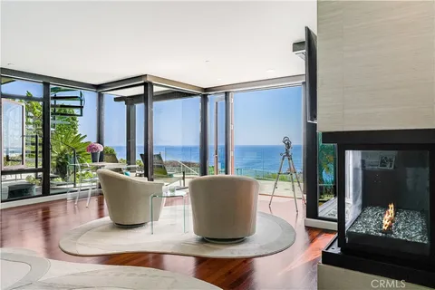 a living room with a couch a flat screen tv and floor to ceiling window
