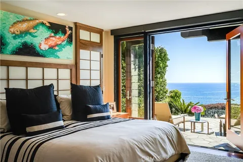 a bedroom with a bed mirror and a window