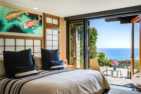 a bedroom with a bed mirror and a window