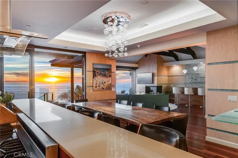 a view of a dining room with furniture a chandelier and wooden floor