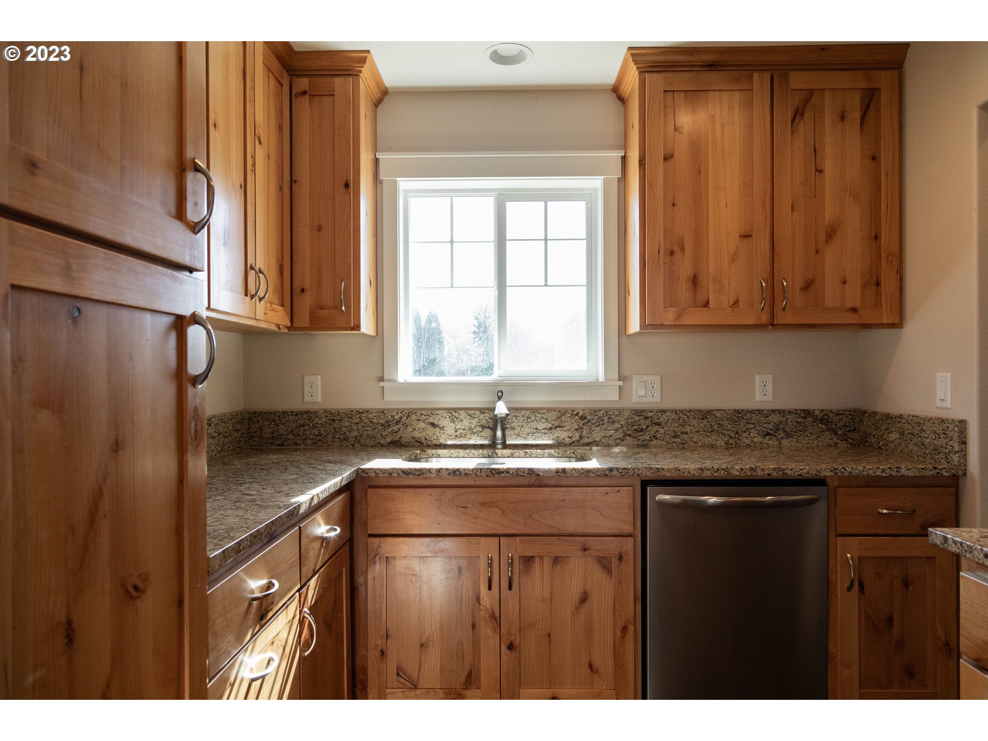 769 Southeast Meadows Loop Sheridan, OR 97378 - Photo 5 of 20 a kitchen with granite countertop a sink window and cabinets
